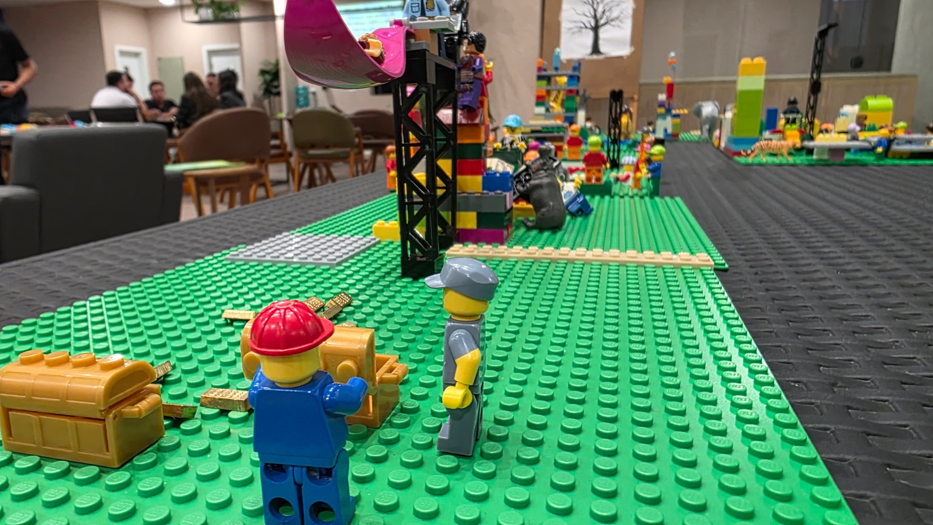 Paisagem LEGO ampla com minifigs e construções representando o sistema