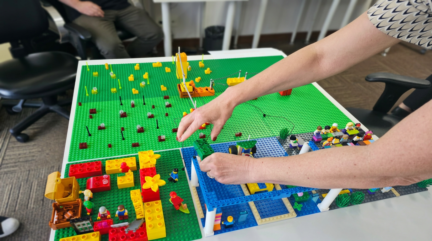 Profissionais em workshop de LEGO Serious Play construindo modelos com peças coloridas